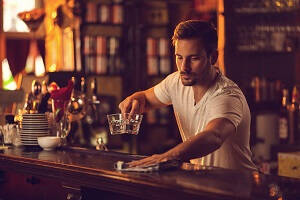How to become a bartender , Male Bartender cleaning the bar