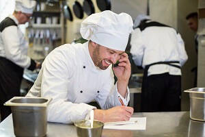 Male Head Chef on the phone ordering ingredients