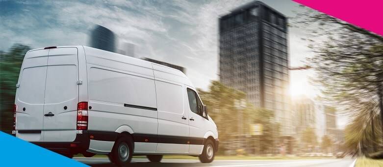 A white Van on the road undertaking a delivery in a built up environment