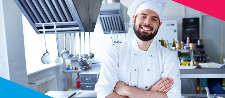 Male chef standing in the kitchen with hands folded