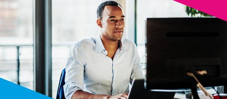 A Personal Assistant working across a laptop and monitor in the office