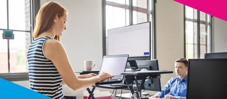 Picture of an office worker standing working on a raised desk