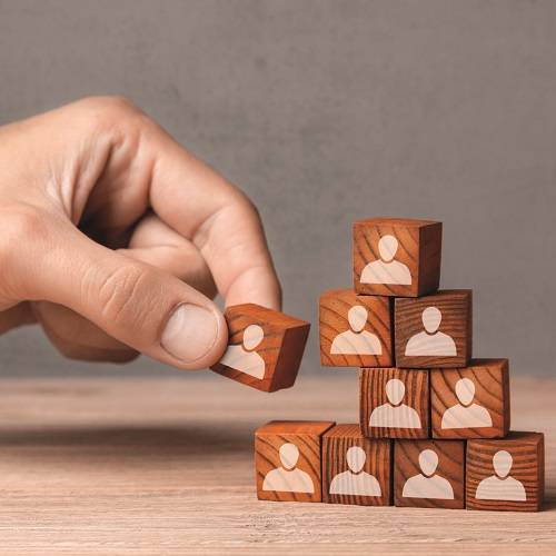 Person removing building block from tower