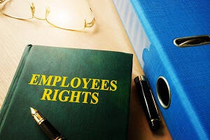 Your rights as a Warehouse Employee - A green book on the desk with "EMPLOYEES RIGHTS" printed on the front