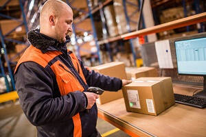 Warehouse Operative Job Description - Male Warehouse Operative Scanning a box 
